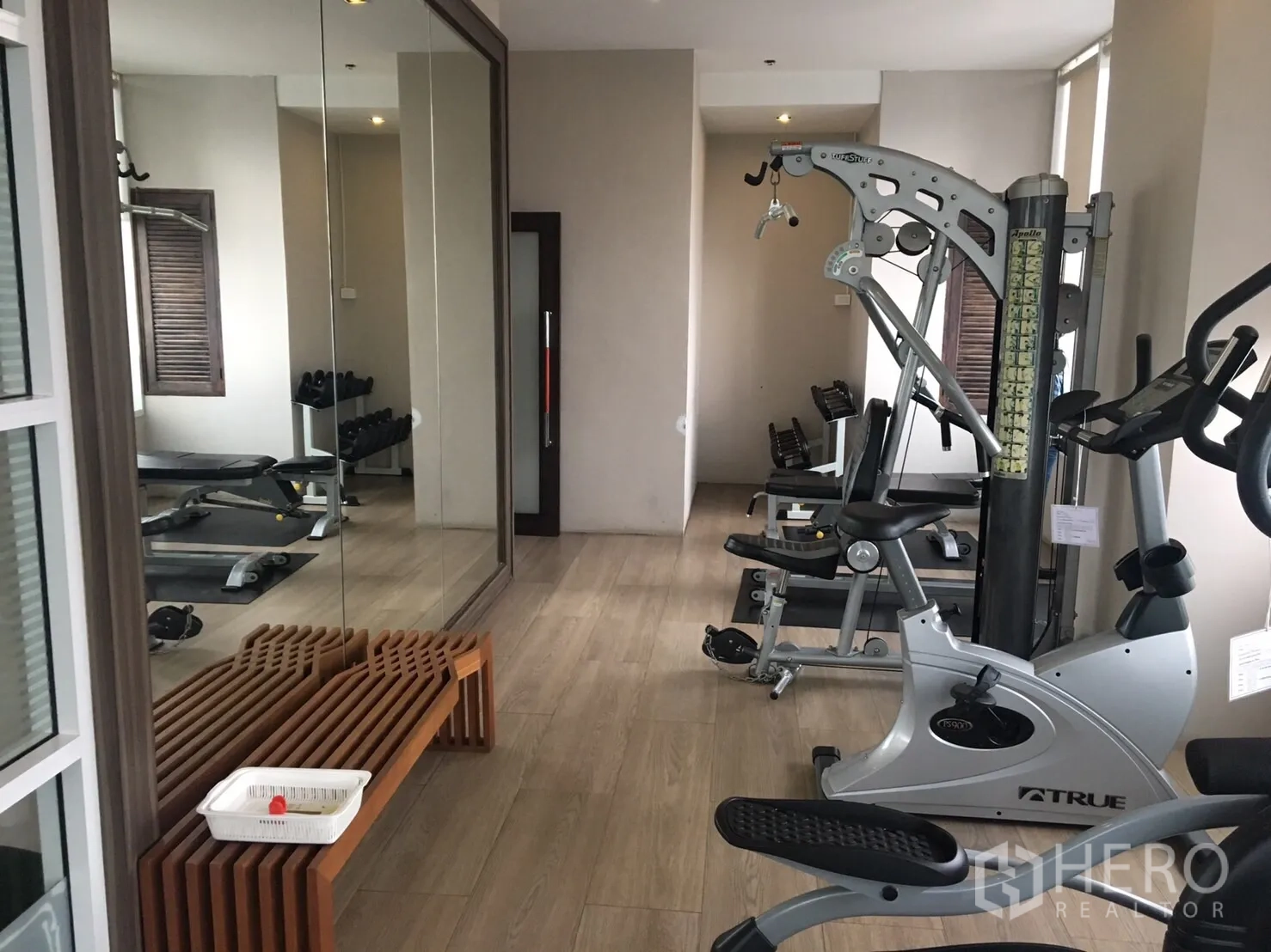 Condominium for rent in Phaya Thai, Bangkok - Condominium fitness room with cardio machines, free weights, mirrors and light wood flooring.
