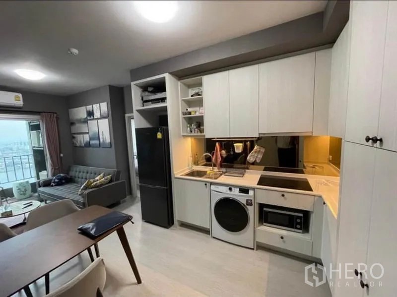 Condominium for sale in Bang Sue, Bangkok - Fitted kitchen with induction hob, sink, ample cabinets, washer and microwave.