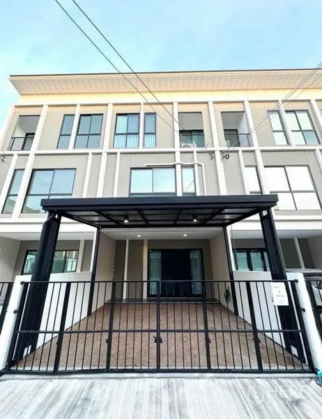 Townhouse for rent - Modern three-storey townhouse facade at Patio Srinakarin–Rama 9 with gated covered carport.