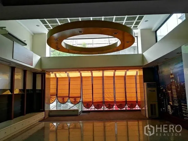 办公空间 出租在Khlong Toei, Bangkok - 中庭空间设大型环形吊顶与带橙色遮阳的高窗。