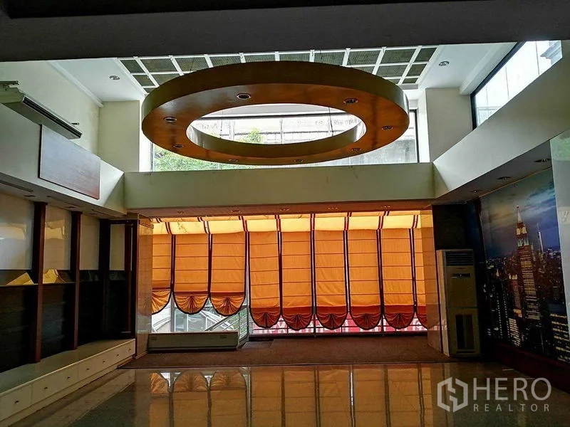 办公空间 出租在Khlong Toei, Bangkok - 中庭空间设大型环形吊顶与带橙色遮阳的高窗。