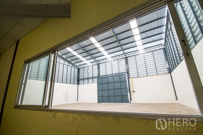 Warehouse for rent - View from an internal office window overlooking the open warehouse floor and entry.