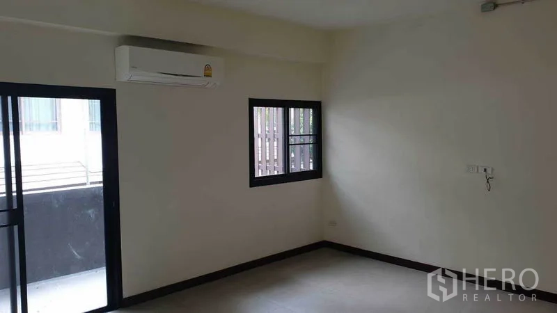 联排别墅 出租或出售在Khlong Toei, Bangkok - 卧室一角，带阳台门与窗户，安装空调。