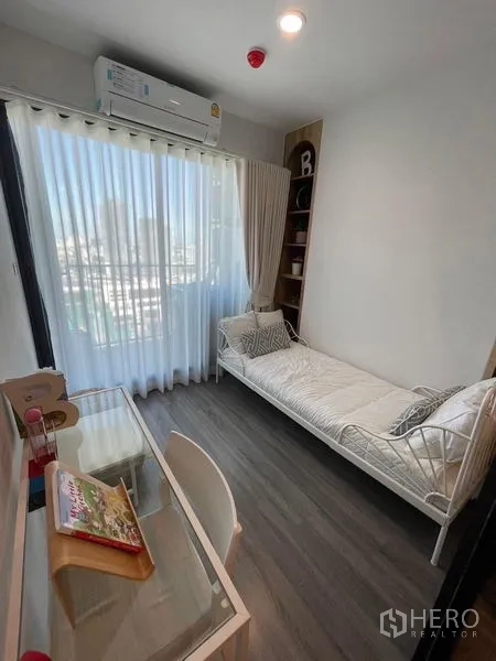 Condominium for rent - Secondary bedroom or study with daybed, work desk and large window with sheer curtains.