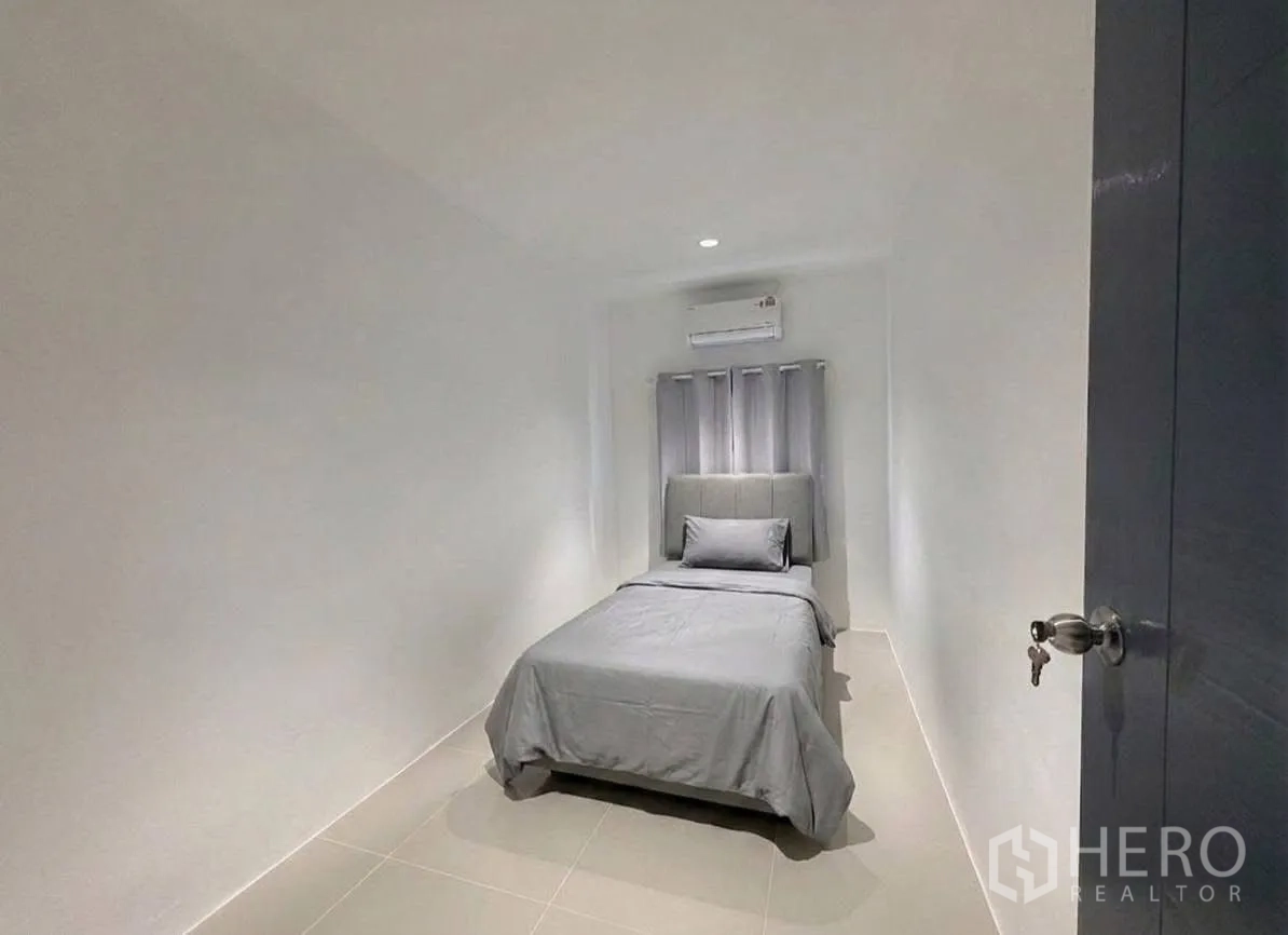 ทาวน์เฮาส์ for rent in Phra Khanong, Bangkok - ห้องนอนขนาดกะทัดรัด เตียงเดี่ยว เครื่องปรับอากาศ และผ้าม่าน.