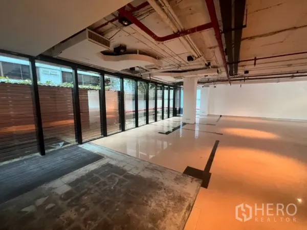 办公空间 出租在Watthana, Bangkok - 沿整排落地窗的开放办公区，面向带屏风的私密露台。
