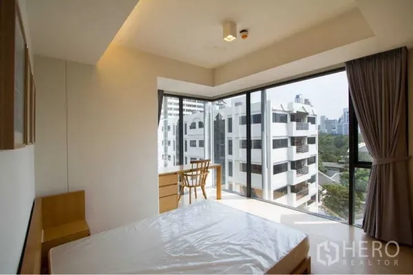 公寓 出租或出售在Watthana, Bangkok - 转角卧室，环幕落地窗配书桌椅与床垫，采光充足，可远眺城市天际线