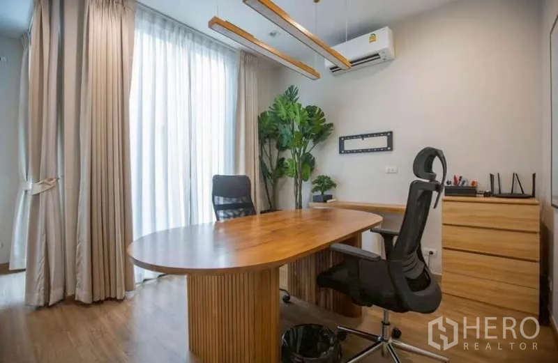 Detached House for rent or sale in Lat Phrao, Bangkok - Home office corner showing full-height curtains and modern pendant lights.