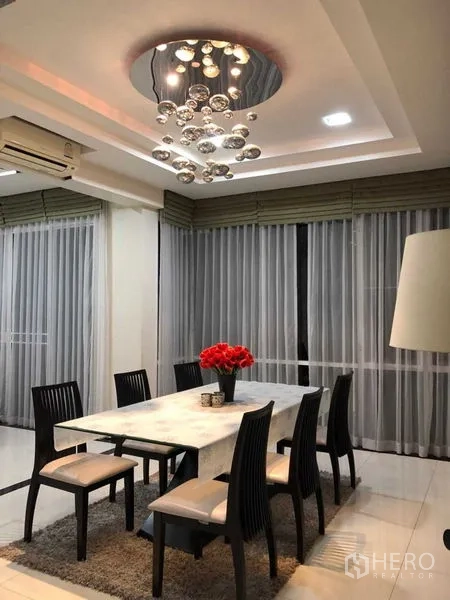 บ้าน ขายในMin Buri, Bangkok - ห้องทานอาหารบรรยากาศช่วงเย็น โคมไฟคริสตัลและผ้าม่านเต็มผนัง