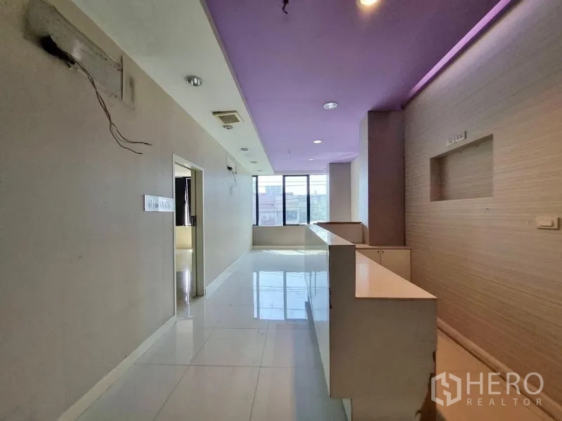 店屋 出租在Watthana, Bangkok - 楼层走道，内置操作台，紫色吊顶与大窗户。