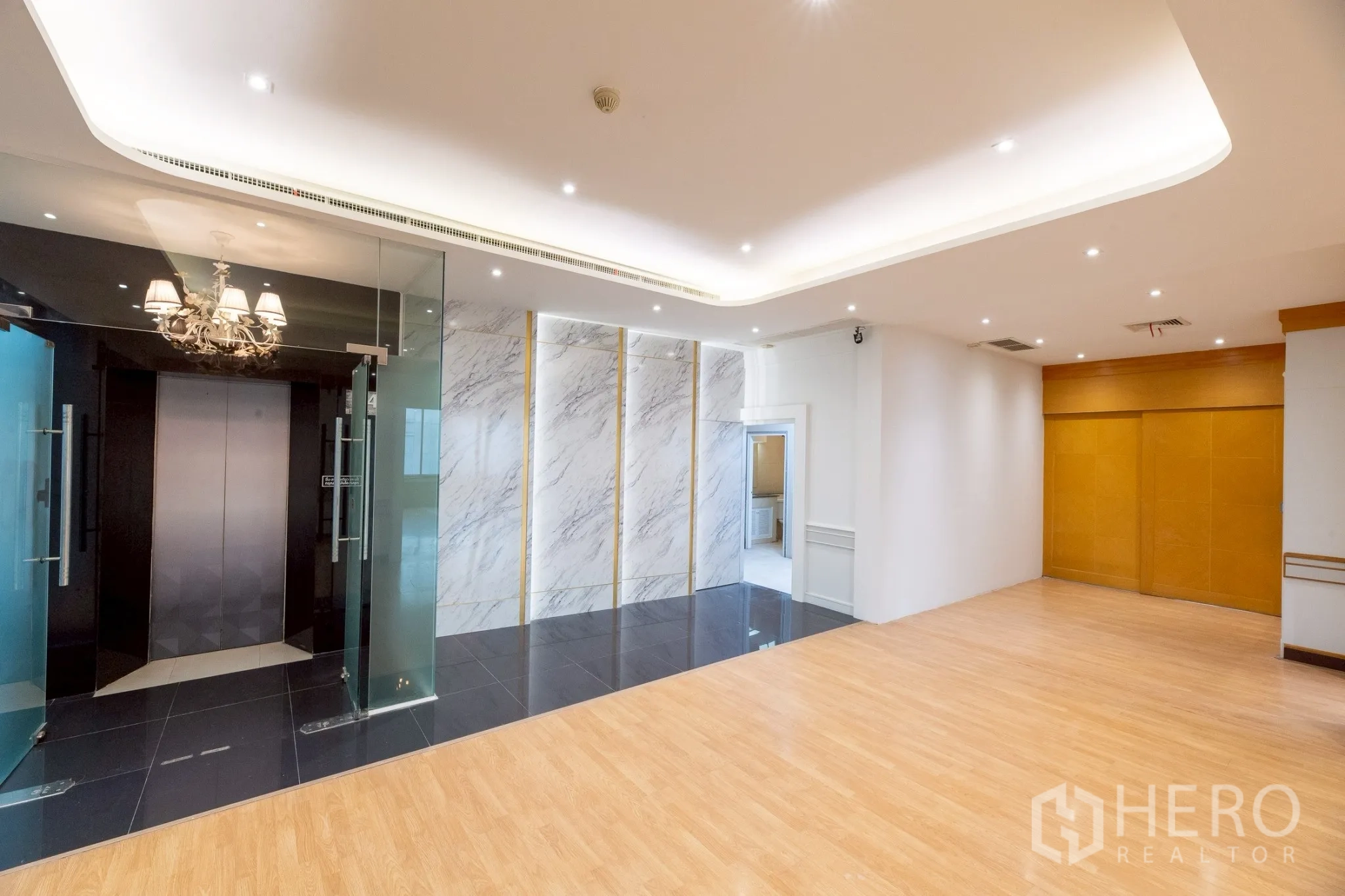 Office Space for rent in Wang Thonglang, Bangkok - Lift lobby featuring marble accent wall, glass doors and wood flooring.