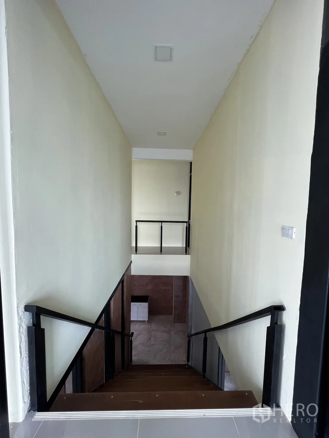 Detached House for rent or sale in Phra Khanong, Bangkok - Stair landing looking down to the ground floor with stone flooring.