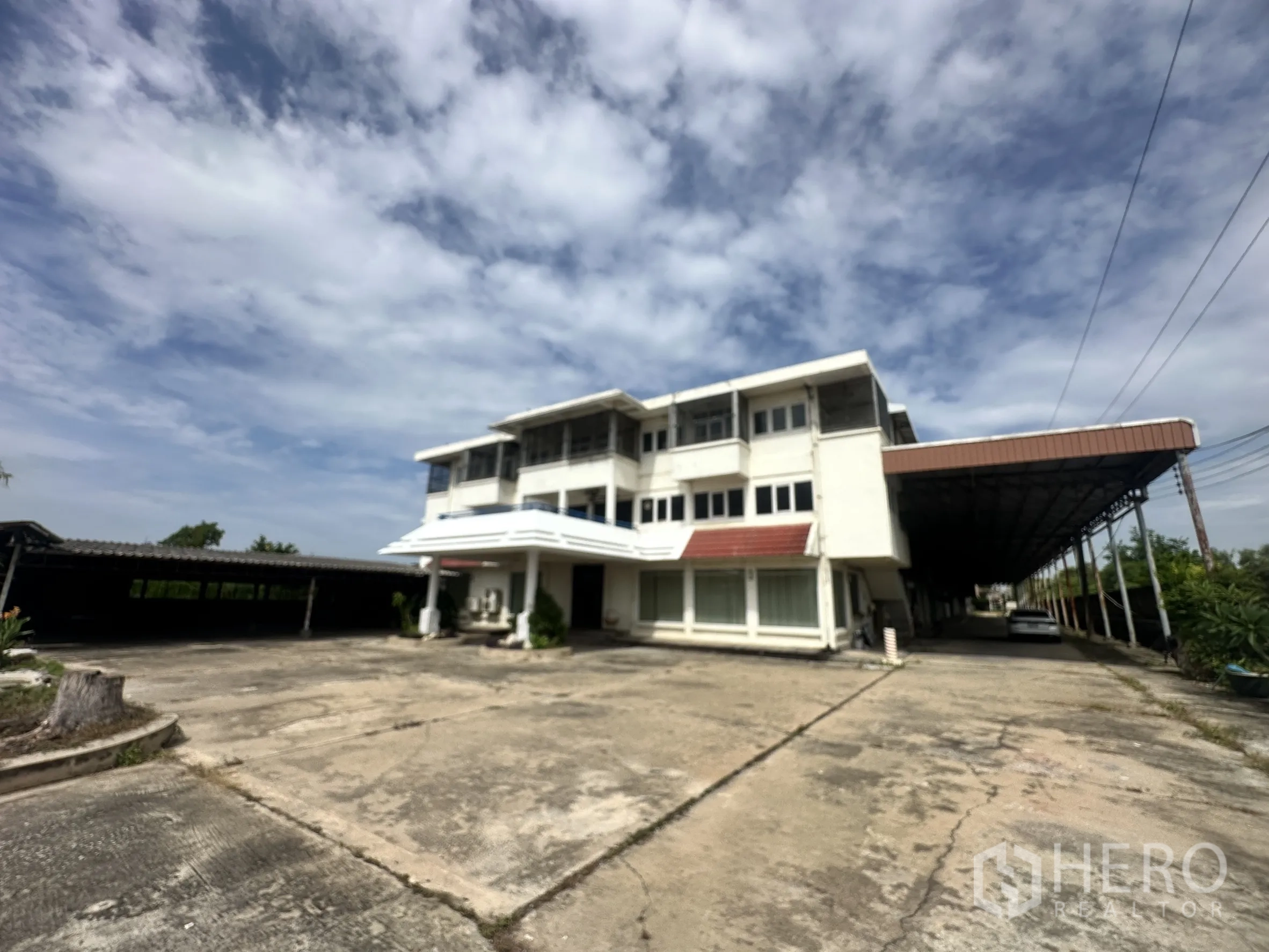 Factory for sale in Sai Noi, Nonthaburi - Multi-storey office building at the front with driveway and parking.