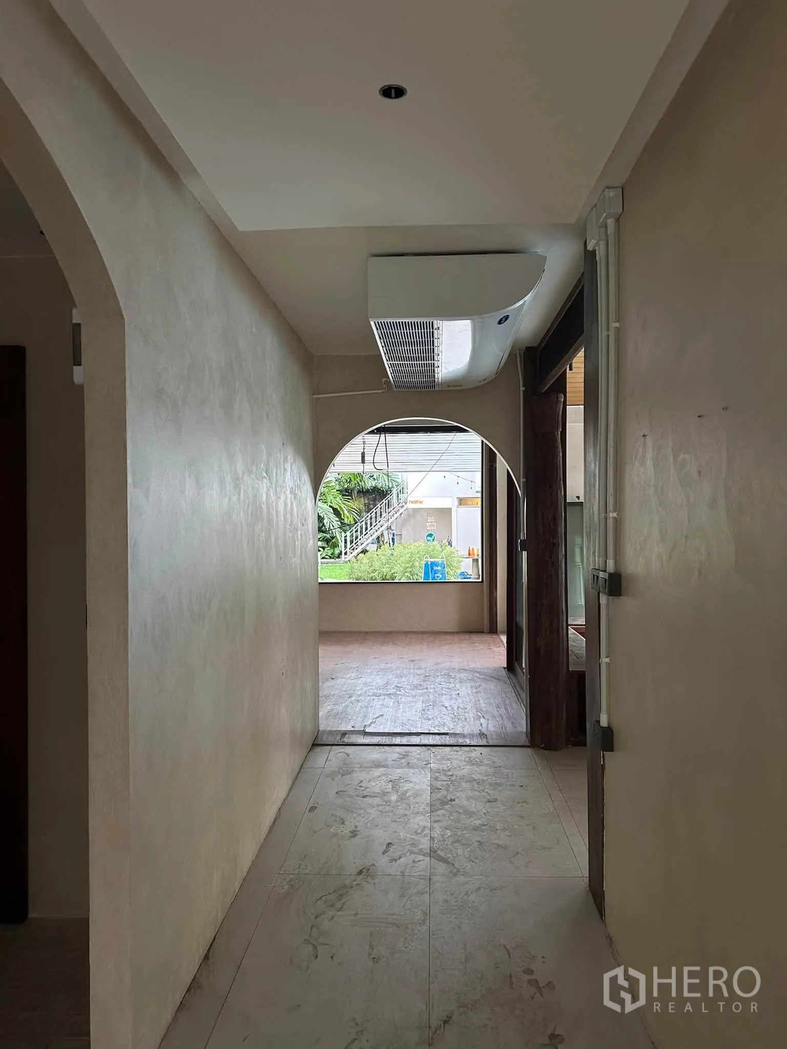 พื้นที่ขายของ for rent in Khlong Toei, Bangkok - โถงซุ้มโค้งเปิดสู่เฉลียงสวนพร้อมต้นไม้และที่นั่ง