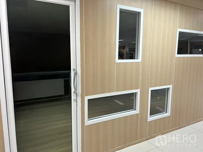 办公空间 出租在Bang Rak, Bangkok - 木纹隔断墙，配白色窗框与玻璃入户门。