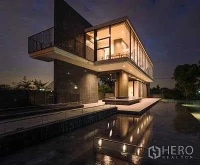 独立式住宅 出租在Prawet, Bangkok - 会所与镜面水池夜景，悬挑二层设计