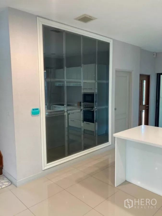 Detached House for rent in Mueang Nonthaburi, Nonthaburi - Glass-partitioned kitchen viewed from the living area with built-in appliances.