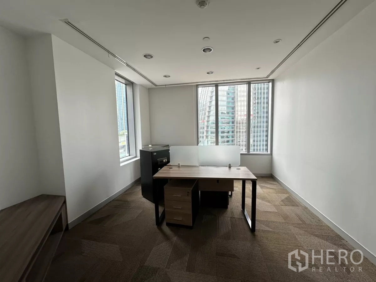 Office Space for rent in Watthana, Bangkok - Bright corner office with a single desk, a safe and large windows.