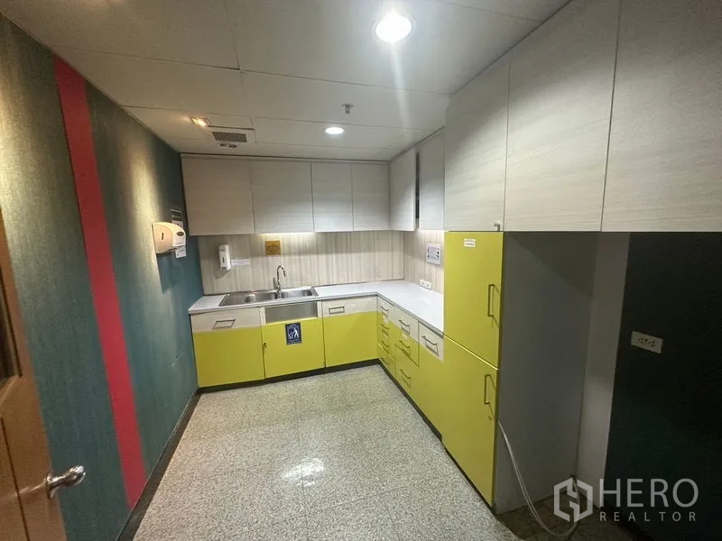 办公空间 出租在Khlong Toei, Bangkok - 紧凑茶水间，L形台面、水槽与黄色下柜