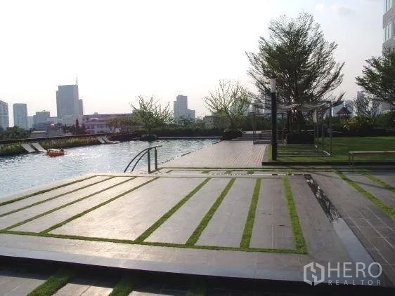 Condominium for rent in Khlong Toei, Bangkok - Poolside terrace with landscaped garden and city views at the condominium.