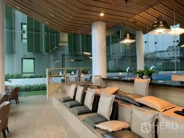 公寓 出售在Ratchathewi, Bangkok - 公寓内的共享休闲区，阶梯式座位、吊灯与花园景观。
