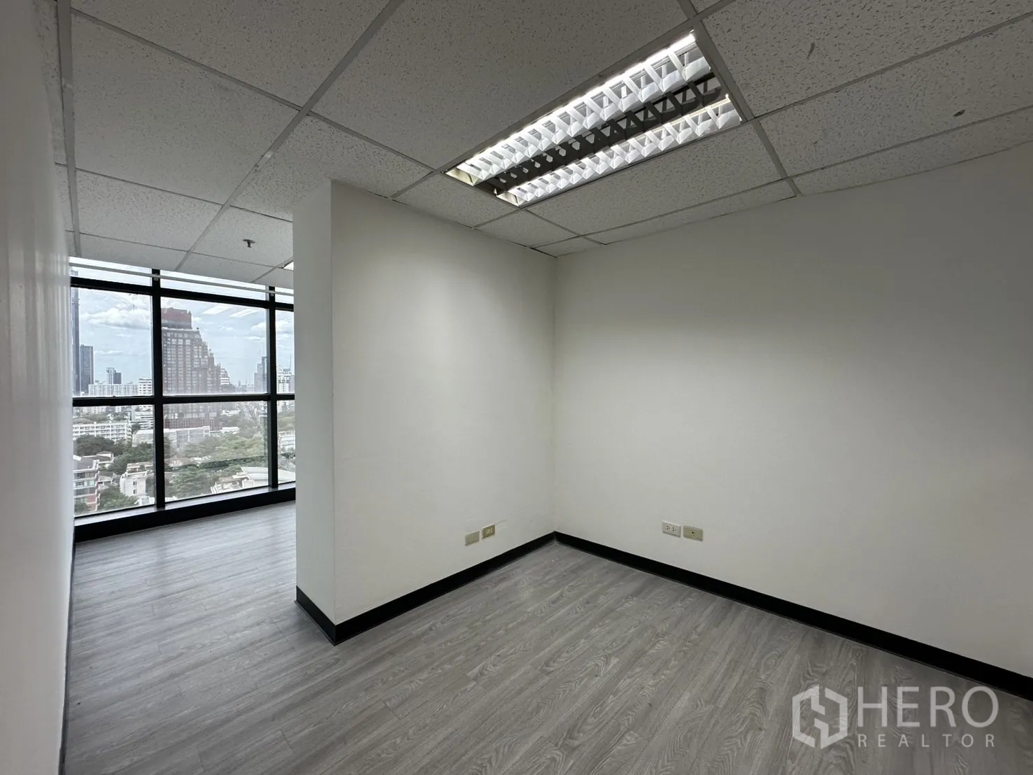办公空间 出租在Watthana, Bangkok - 私密小型办公室，大窗与白色墙面、荧光灯，眺望曼谷景色。