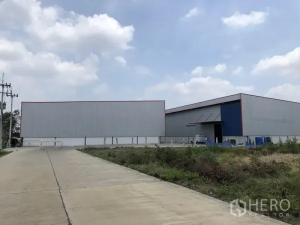 Factory for rent or sale in Phra Nakhon Si Ayutthaya - Front approach to modern steel-clad factory warehouses with wide truck access.