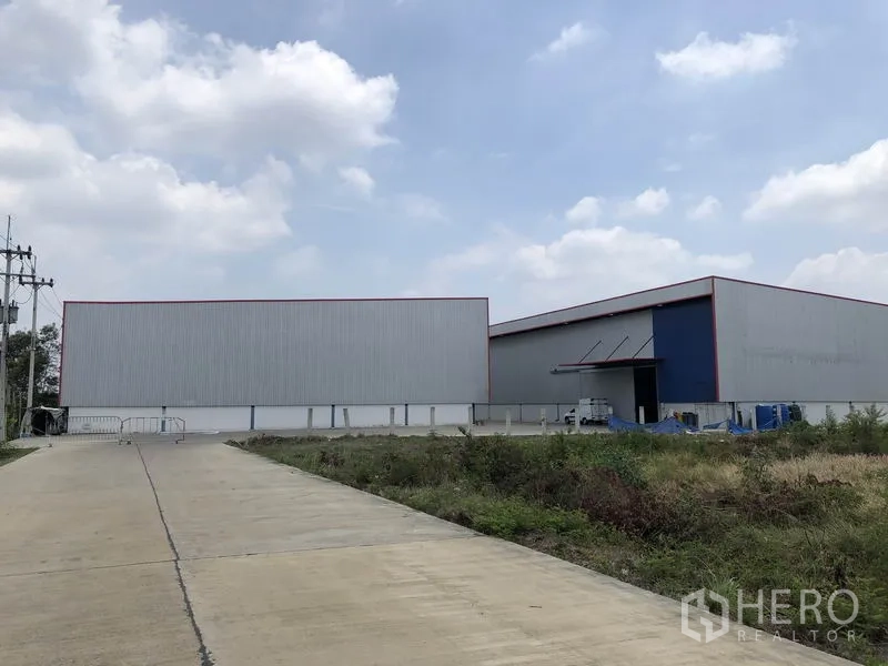 Factory for rent or sale in Phra Nakhon Si Ayutthaya - Front approach to modern steel-clad factory warehouses with wide truck access.