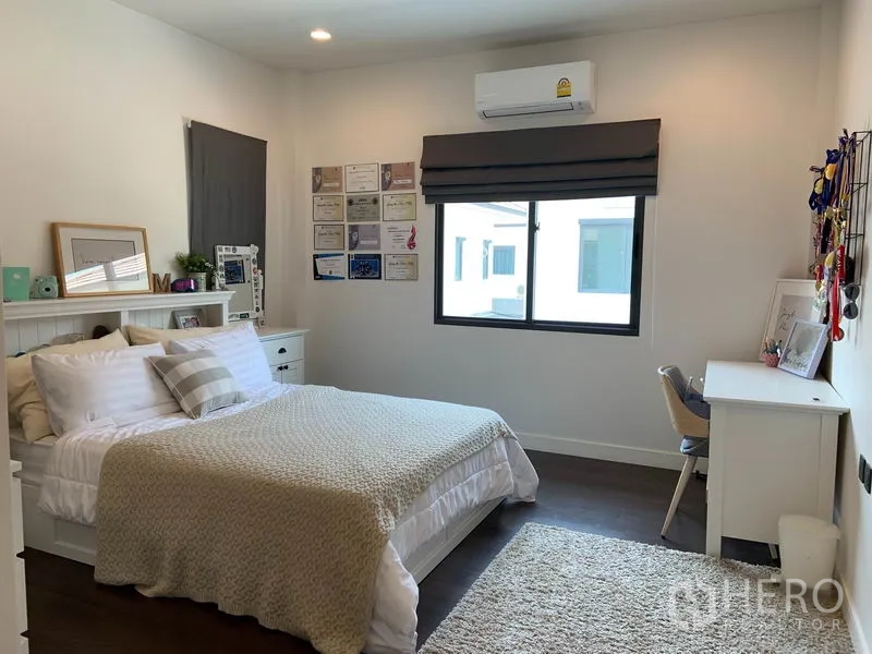 Detached House for rent or sale in Bang Kapi, Bangkok - Cozy bedroom with double bed, study desk and window light.