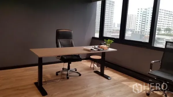 Office Space for rent in Khlong Toei, Bangkok - Executive office desk by wide windows with Bangkok city views on light wood flooring.