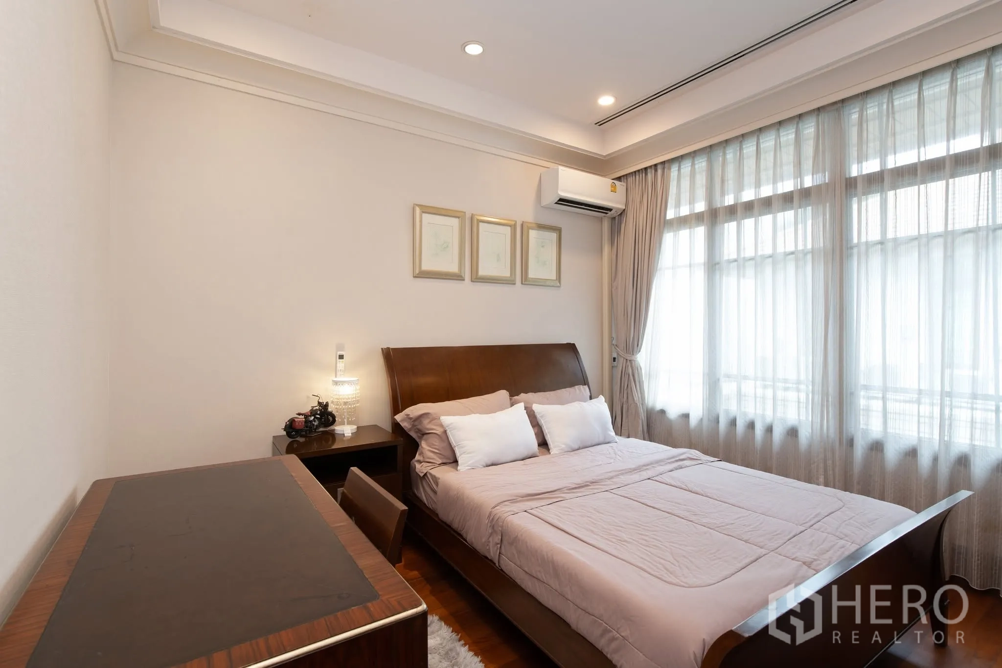 บ้านเดี่ยว for rent or sale in Watthana, Bangkok - ห้องนอนแขกพร้อมเตียงไม้ โต๊ะทำงาน และแสงไฟนุ่มนวล