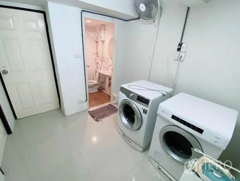 联排别墅 出租在Wang Thonglang, Bangkok - 洗衣房配前置洗衣机和烘干机，旁边为小型卫生间。