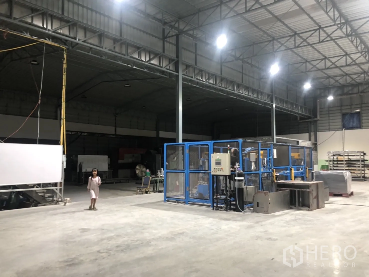 Warehouse for sale in Lam Luk Ka, Pathum Thani - Open production floor with steel trusses, machinery zones, and polished concrete surface.