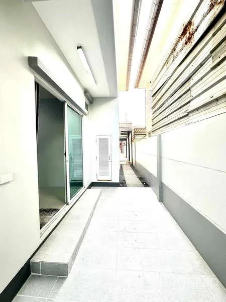 Detached House for rent in Lat Krabang, Bangkok - Side yard walkway with sliding glass door and high privacy walls.