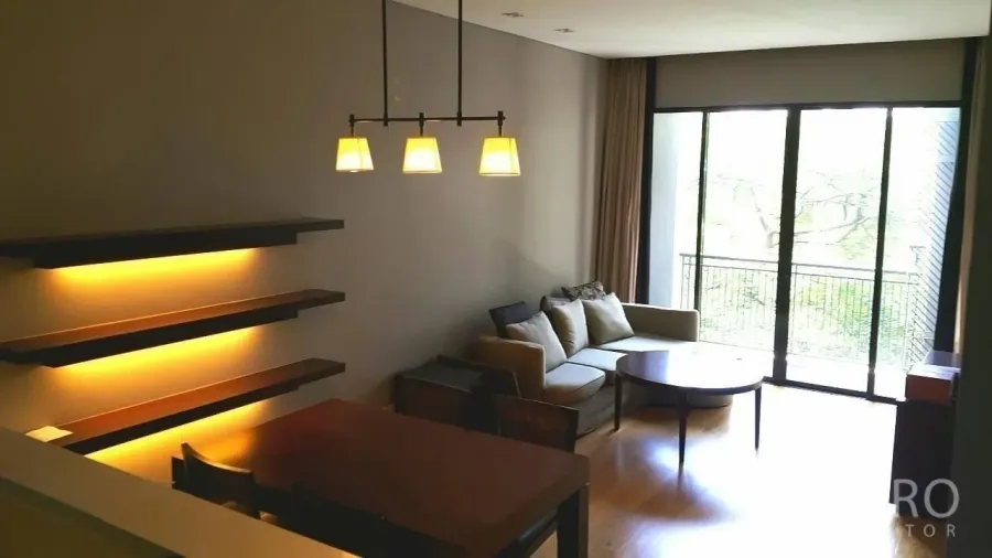 คอนโด ขายในWatthana, Bangkok - ห้องนั่งเล่นสว่างพร้อมหน้าต่างเต็มบาน ระเบียงวิวต้นไม้ โซฟา โต้ะทานข้าว และไฟวอล์ลไลท์ ในคอนโดโซนทองหล่อ