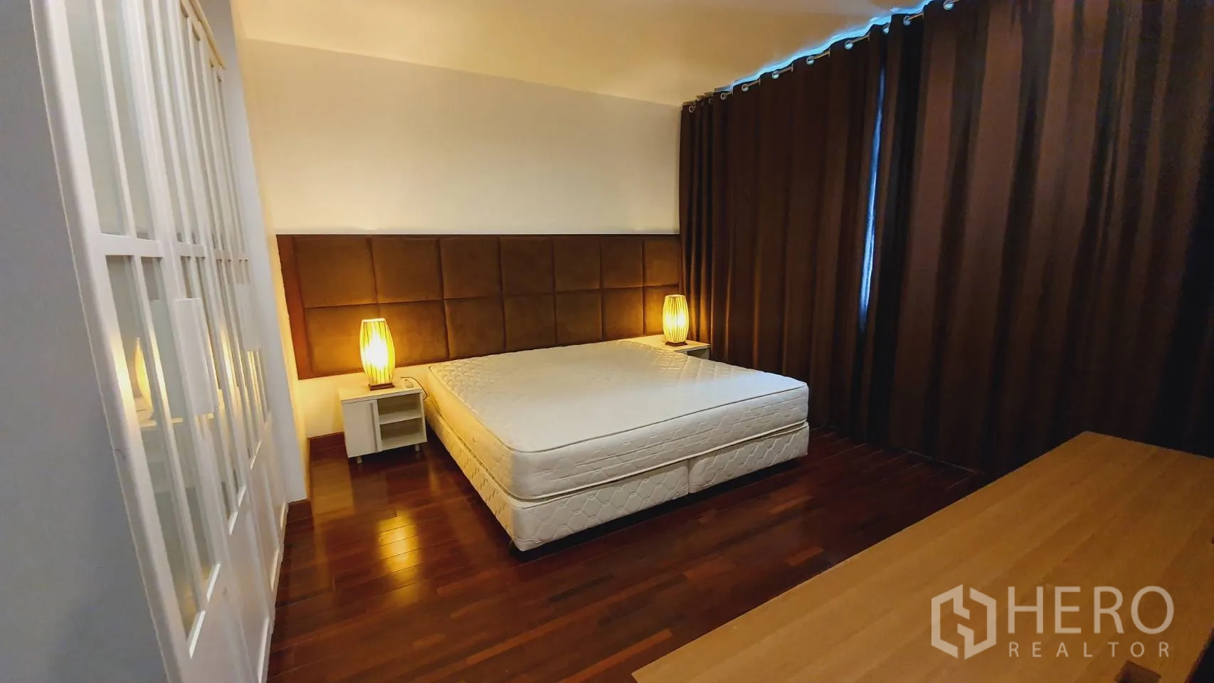 公寓 出租在Khlong Toei, Bangkok - 主卧带大床、床头灯、衣柜和深色窗帘。