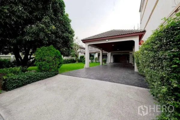 Detached House for rent or sale in Phra Khanong, Bangkok - Wide driveway and covered carport beside the landscaped garden of the Phra Khanong detached home.