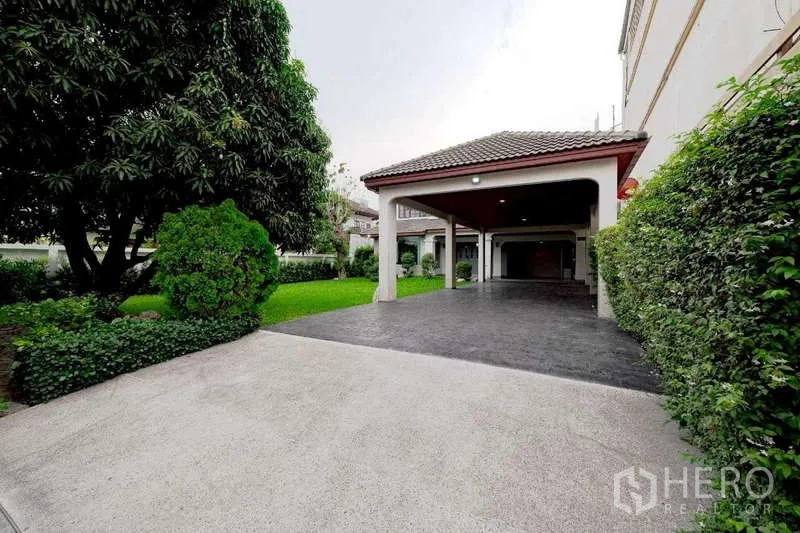 Detached House for rent or sale in Phra Khanong, Bangkok - Wide driveway and covered carport beside the landscaped garden of the Phra Khanong detached home.