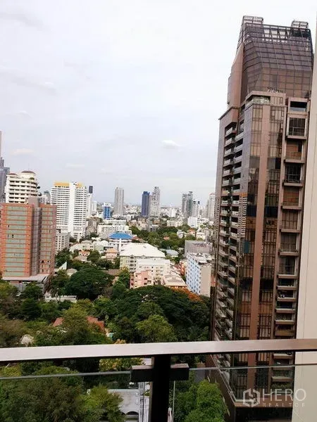Condominium for rent or sale in Watthana, Bangkok - High-floor balcony view over the Sukhumvit skyline and green pockets in Watthana, Bangkok.