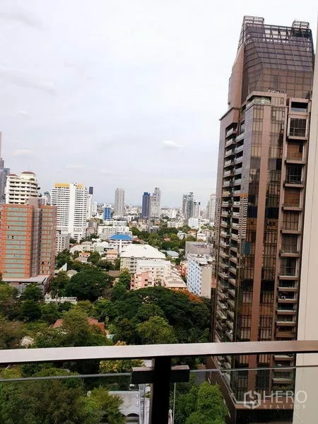 Condominium for rent or sale in Watthana, Bangkok - High-floor balcony view over the Sukhumvit skyline and green pockets in Watthana, Bangkok.