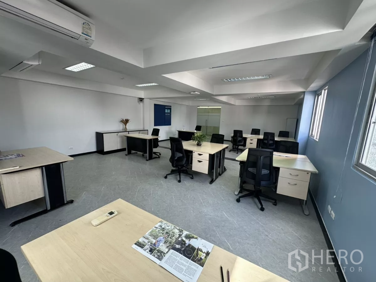 Office Space for rent in Watthana, Bangkok - Bright office area with several desks, potted plant decor and a glass meeting-room door in the background.