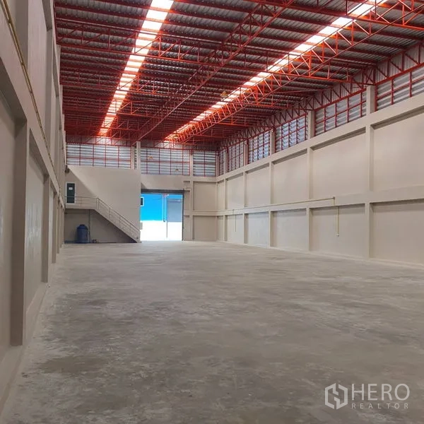 Warehouse for rent in Mueang Samut Sakhon, Samut Sakhon - Wide clear-span warehouse with polished concrete floor, large loading door and stair access to the office.