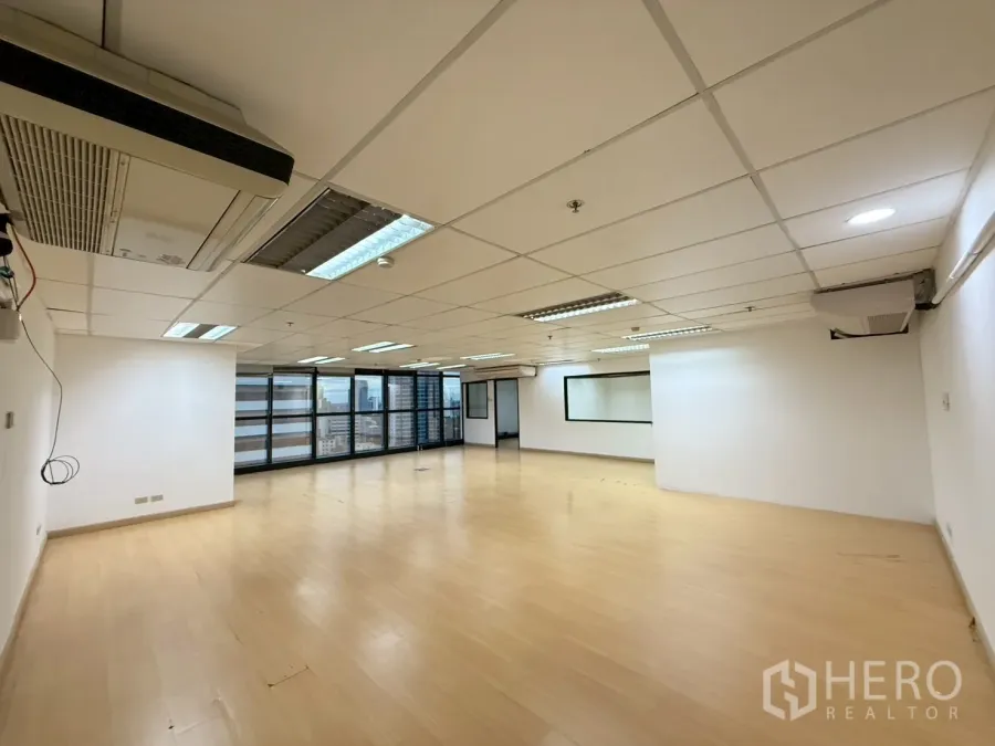 Office Space for rent in Watthana, Bangkok - Spacious office area with a long run of glass windows, skyline views and wall-mounted air conditioners.