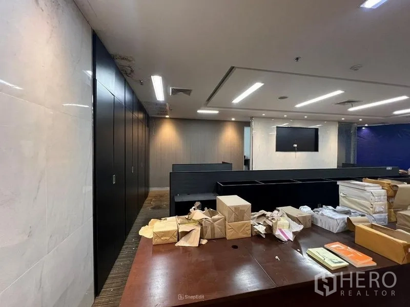 Retail Space for rent - Interior view showing dark storage cabinets, a marble accent wall, workstations and recessed lighting.