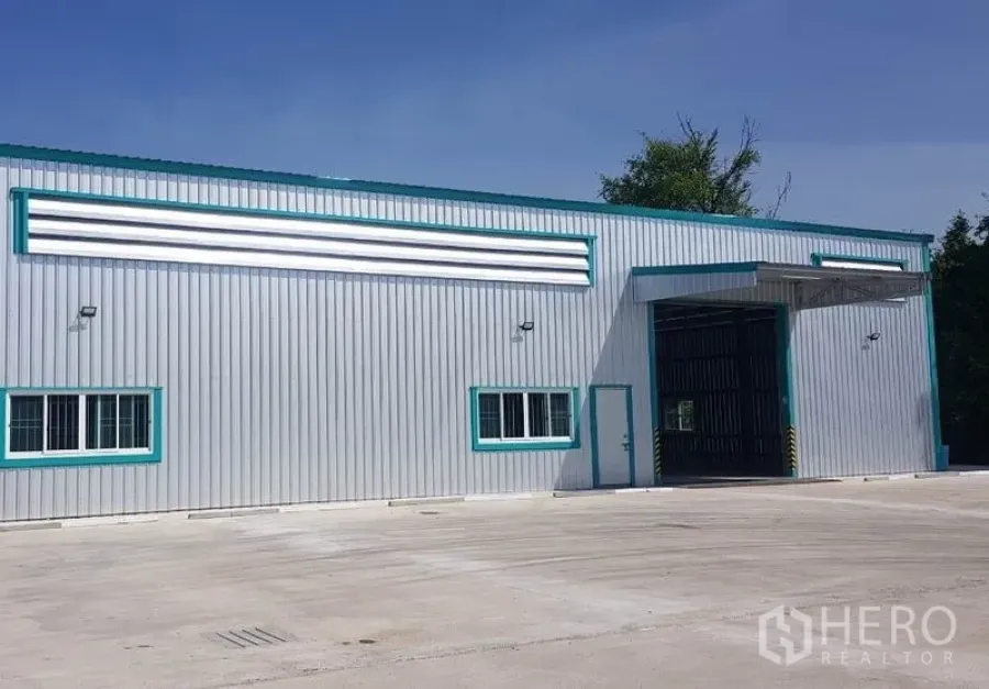 Warehouse for rent in Mueang Nonthaburi, Nonthaburi - Modern steel-clad warehouse exterior with wide loading door and a large concrete yard.