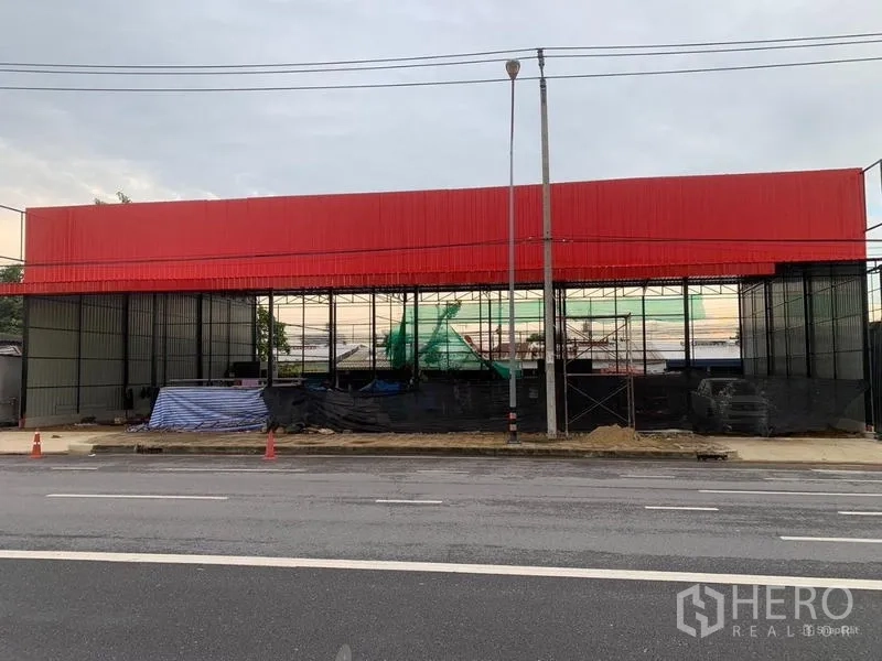 Warehouse for rent in Bueng Kum, Bangkok - Street-front steel-frame warehouse with a red metal facade and wide frontage in Bueng Kum, Bangkok.