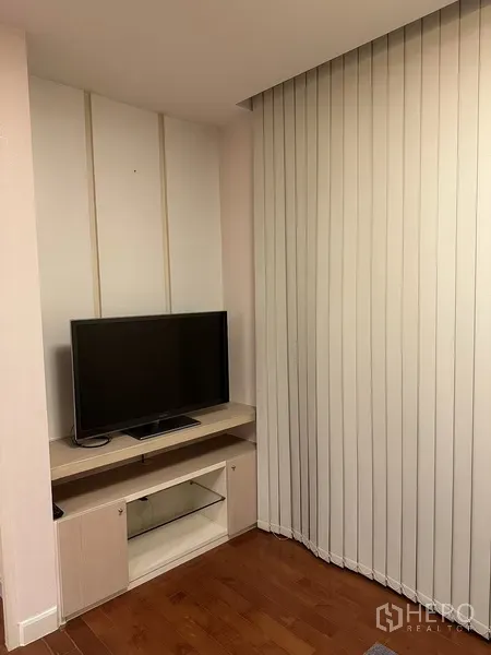 公寓 出租在Watthana, Bangkok - 紧凑客厅角落，低矮电视柜旁为落地竖百叶帘。