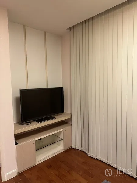 公寓 出租在Watthana, Bangkok - 紧凑客厅角落，低矮电视柜旁为落地竖百叶帘。