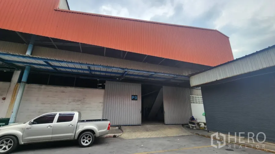 Warehouse for rent in Mueang Samut Prakan, Samut Prakan - Steel-clad warehouse exterior with wide sliding doors and a covered loading bay in Mueang Samut Prakan.