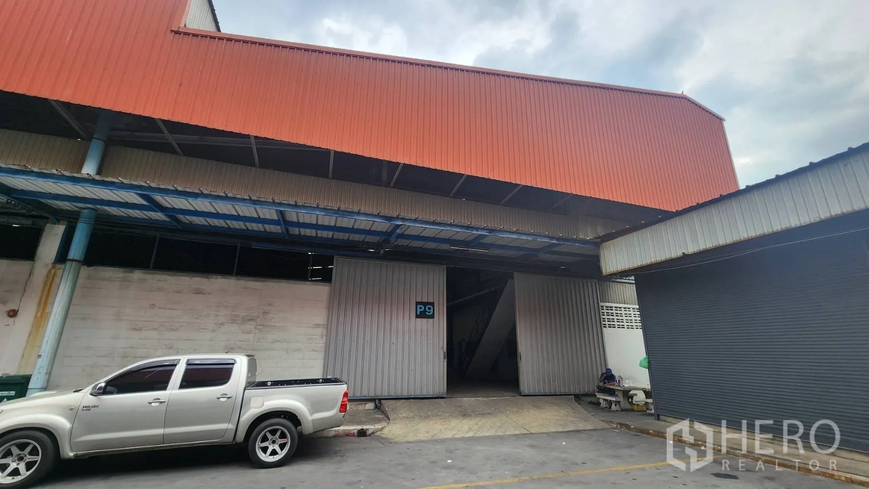 Warehouse for rent in Mueang Samut Prakan, Samut Prakan - Steel-clad warehouse exterior with wide sliding doors and a covered loading bay in Mueang Samut Prakan.